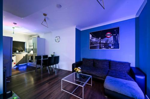 a blue living room with a couch and a table at Beautiful Modern Apartment on Wick Lane in London