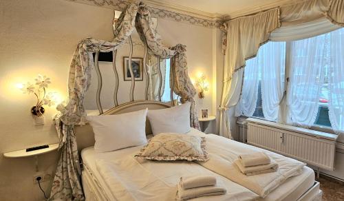 a bedroom with a canopy bed and a window at Haus Schaper in Westerland