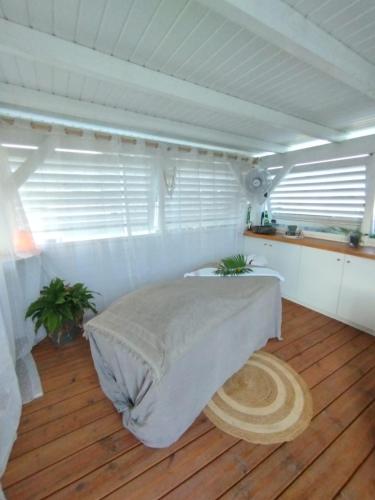a bedroom with a bed and a wooden floor at Logement chic au style tropical contemporain in Îlet à Christophe