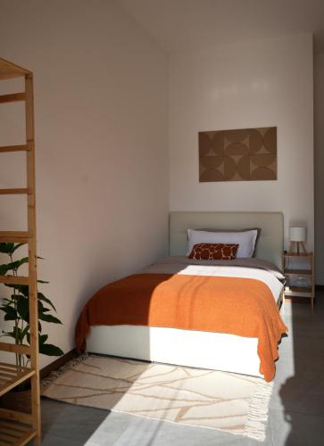 a bedroom with a bed with an orange blanket at UNIque Apt Bergamo 2 in Bergamo