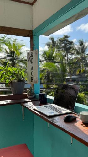 a laptop computer sitting on a table next to a window at Soul Rebel Hostel in Puerto Viejo