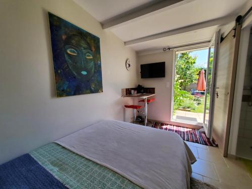una camera da letto con un letto e un quadro sul muro di La petite maison a Libourne