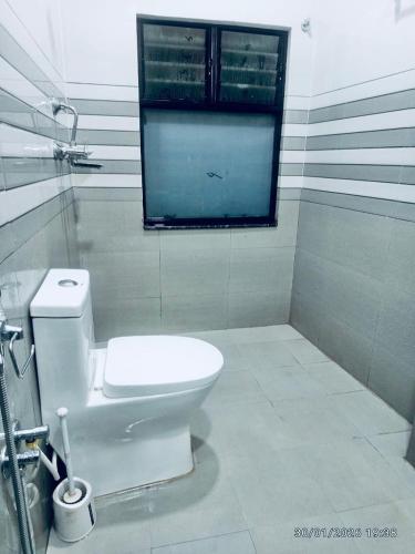 a bathroom with a white toilet and a window at The Himalayan Homes in Tokna