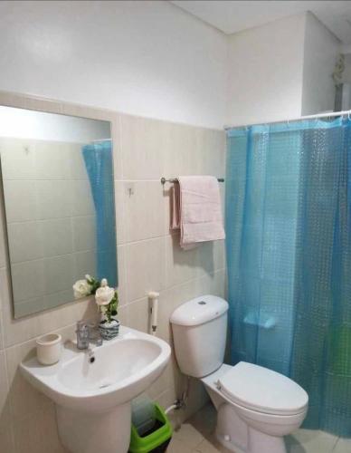 a bathroom with a toilet and a sink and a shower at Urban haven Family&Barkada room in Manila