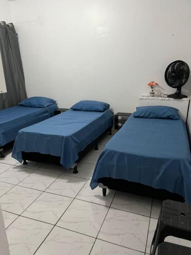 two beds in a hospital room with blue sheets at Espaço Ideal 1 com 2 Quartos in Cascavel