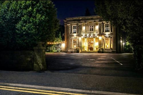 a large building with lights on it at night at Manor House Hotel, Cockermouth in Cockermouth