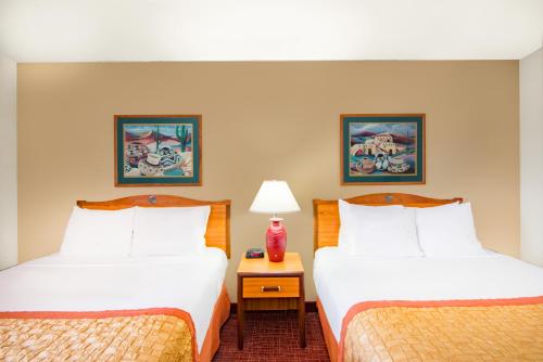 a hotel room with two beds and a table with a lamp at Hawthorn Suites by Wyndham Albuquerque in Albuquerque