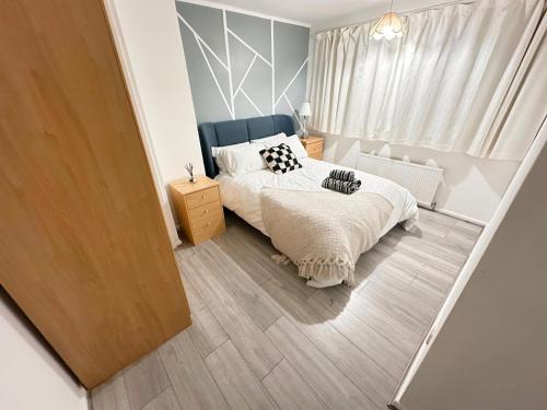 a small bedroom with a bed and a window at Luton Airport Accomodation in Luton