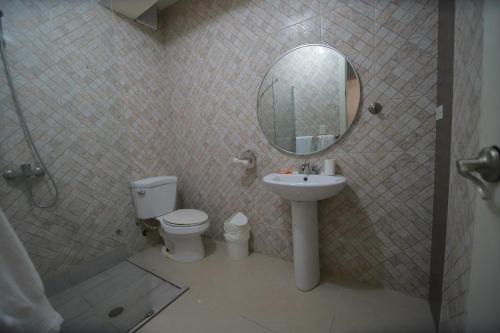a bathroom with a toilet and a sink and a mirror at El Mar Azul Franchecis hostal in Juan Dolio