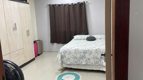 a bedroom with a bed and a window at Casa com piscina in Araruama