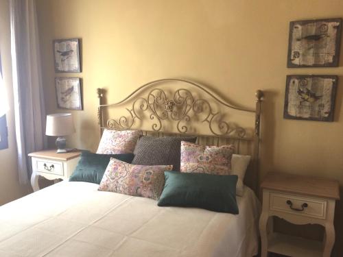 1 dormitorio con 1 cama blanca grande con almohadas en Apartamentos Homelife Coliseo, en Toledo