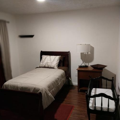 a bedroom with a bed and a dresser and a lamp at The Elect at Pinewood in Millbrook