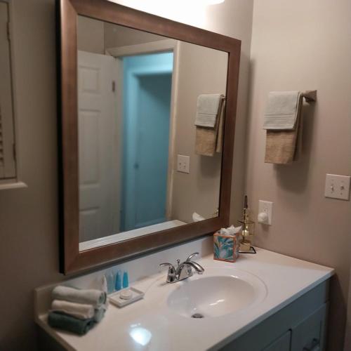 a bathroom sink with a large mirror above it at The Elect at Pinewood in Millbrook