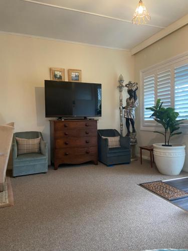 a living room with a large flat screen tv at Katoomba Cosy Cottage- entire 65sqm cottage in Katoomba