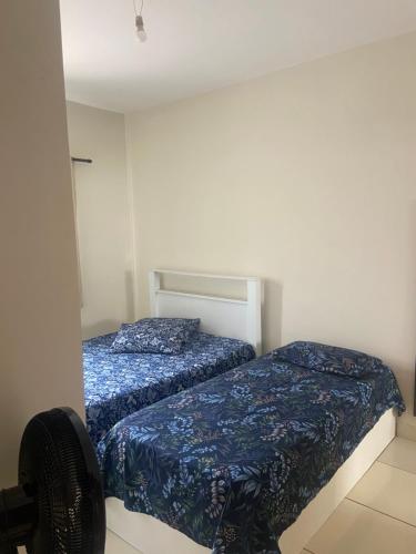 a bedroom with two beds and a chair at Casa Aconchegante Alfenas in Alfenas