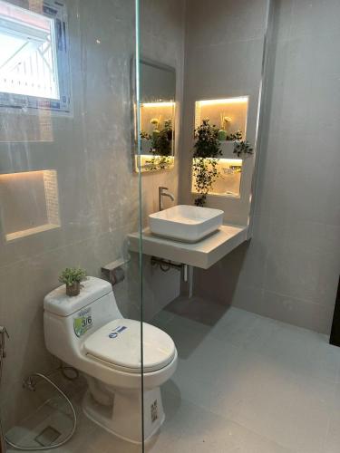 a bathroom with a toilet and a sink at Tree House in Ban Rangeng