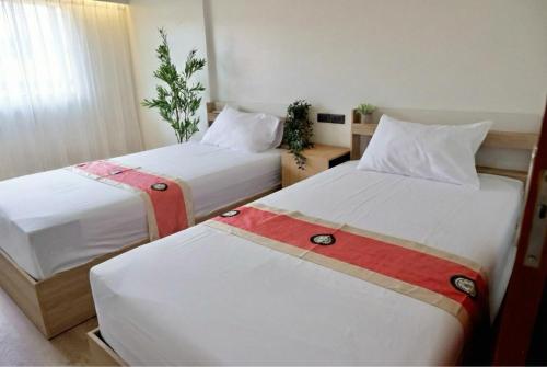 a hotel room with two beds with white sheets at Tree House in Ban Rangeng