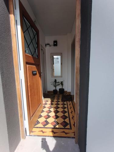 a hallway with a door and a checkered floor at San Lorenzo I in Chacabuco