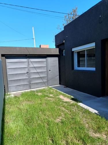 a black house with two garage doors and a yard at San Lorenzo I in Chacabuco