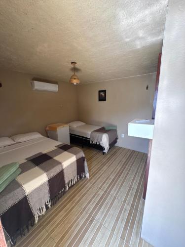 a hotel room with two beds in a room at Barra Adventure Pousada in Mataraca