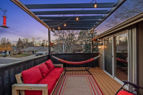 a porch with a red couch and a hammock at The Loveland Haus in Loveland