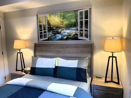 a bedroom with a bed with two windows at Black Bears Den, Heated Pool, Hot Tub, AC, brand new unit! in Canmore