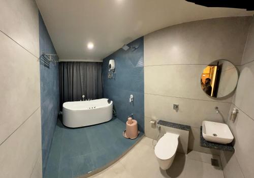 a bathroom with a sink and a toilet and a mirror at Hotel Vallabh Sky in Goya Gate