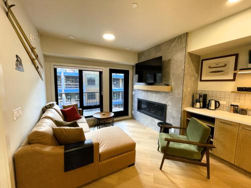 a living room with a couch and a chair at Black Bears Den, Heated Pool, Hot Tub, AC, brand new unit! in Canmore