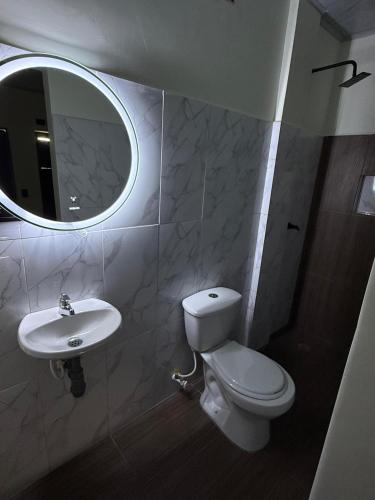 a bathroom with a toilet and a sink and a mirror at Hotel ANY in Los Córdobas