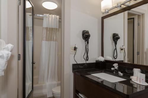 uma casa de banho com um lavatório, um chuveiro e um telefone em Ramada by Wyndham Boston em Boston