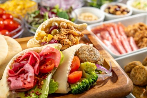 a wooden cutting board with sandwiches and other foods at Hotel Mystays Premier Hamamatsucho in Tokyo