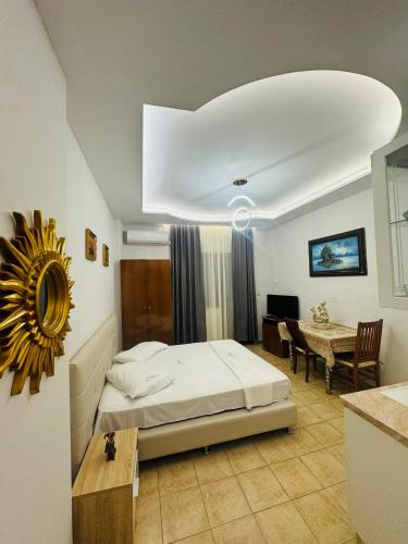 a bedroom with a bed and a table in a room at Hotel Dragoi in Velipojë