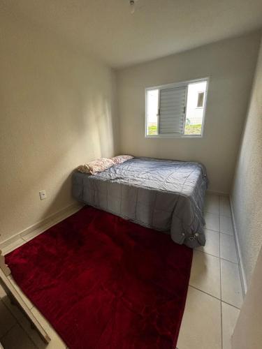 a small bedroom with a bed and a red rug at Prince House in Piracicaba