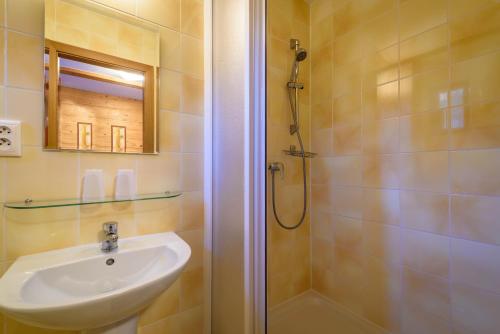 a bathroom with a sink and a shower at Penzion Sagan in Terchová