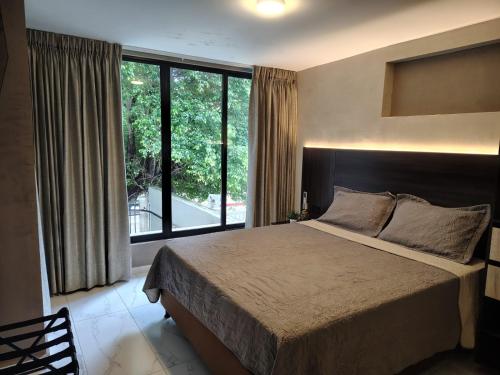 a bedroom with a large bed and a large window at Laureles del parque loft in Barranquilla