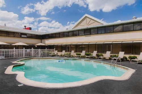 
a swimming pool with a pool table and chairs at Ramada by Wyndham Boston in Boston
