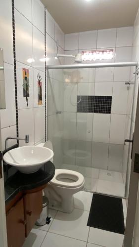 a white bathroom with a toilet and a sink at Pousada e Restaurante Coração De Mãe in Prado