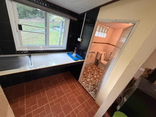 a bathroom with a tub and a toilet and a window at MICKaL in Bang Hin Chang (1)