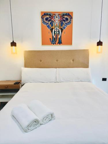 a white bed with a white towel on it at LA VILLA by luxury Attilan in San Pedro La Laguna