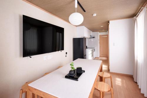 a kitchen with a white table and a tv on a wall at とまりーとStay 立会川 Tomareat Stay Tachiaigawa in Tokyo