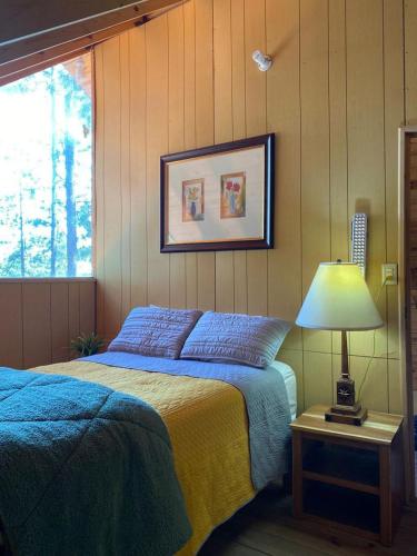 a bedroom with a bed and a lamp on a table at Cabañas El Ensueño in La Ciudad