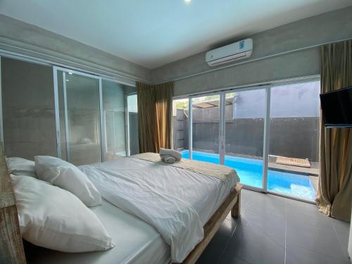 a bedroom with a bed with a view of a pool at Villa Kulat in Uluwatu