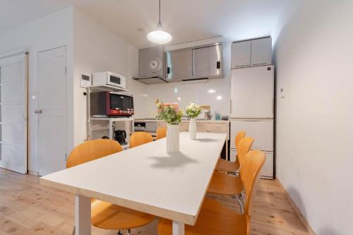 a kitchen and dining room with a white table and chairs at Perfect Shonan in Fujisawa