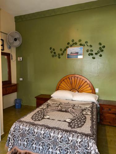 ein Schlafzimmer mit einem Bett und einer grünen Wand in der Unterkunft Hotel Principal in Coatepec