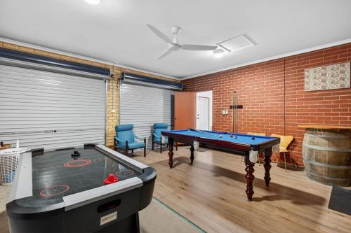 a room with a pool table and a brick wall at 10 Rupara Family Beach House with Sea Views Linen Included in Hayborough