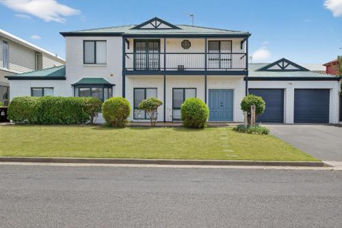 a large white house with a porch on a street at 10 Rupara Family Beach House with Sea Views Linen Included in Hayborough