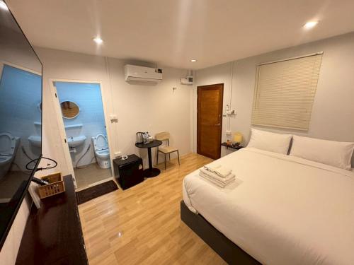 a bedroom with a bed and a bathroom with two toilets at บ้านสุดซอย-Baan Sud Soi in Prachuap Khiri Khan