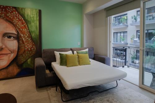 a room with a bed and a painting of a woman at Pavilion 307 in Puerto Vallarta