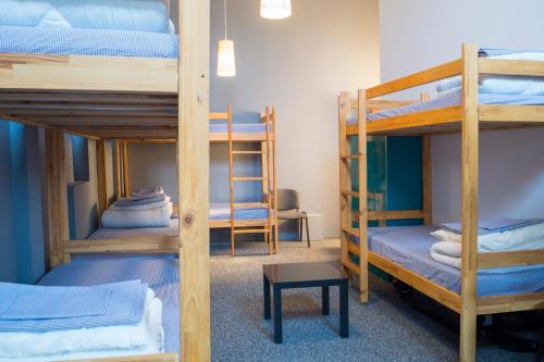 a room with three bunk beds and a table at GO Hostel Rewolucji in Łódź