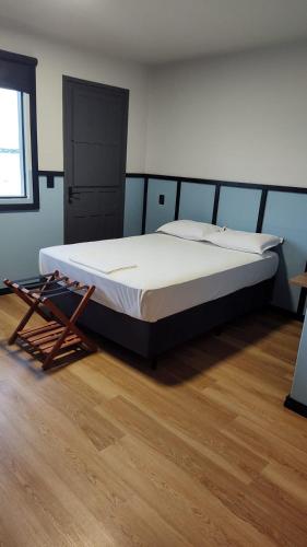 a large bed in a room with a wooden floor at Hotel Lagoa in Laguna